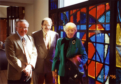 Stained glass windows with people standing in front of them