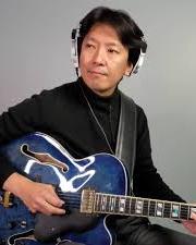 A person sitting with a blue electric guitar